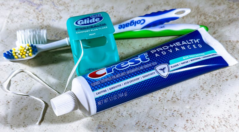 Dental care items including toothbrush, floss, and toothpaste for oral hygiene