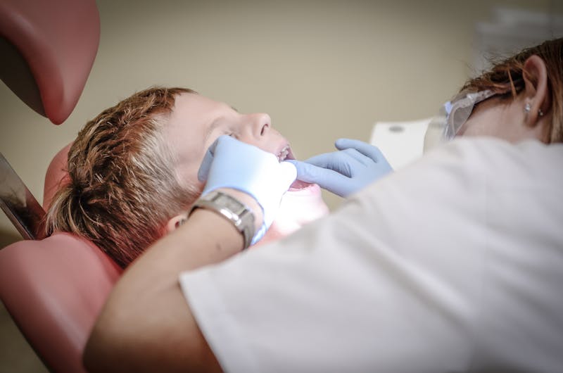 Young boy getting a dental examination by a dentist